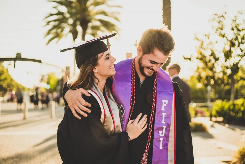 Two graduates hugging after their ceremony