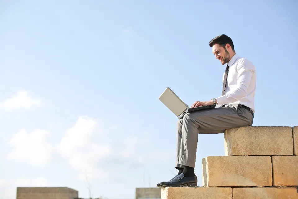 A professional working on a laptop outdoors